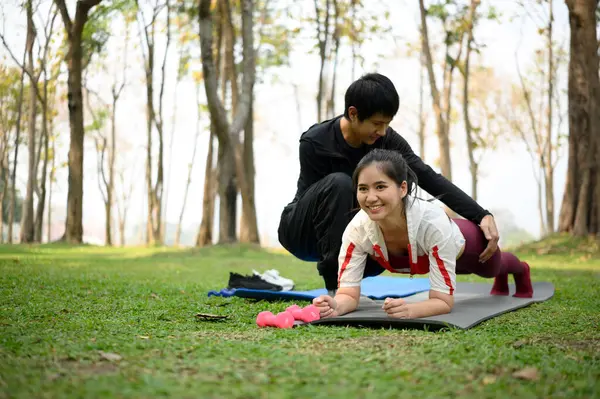 Adam parkta spor yaparken ortağına yardım ediyor. Sağlıklı yaşam tarzı kavramı.