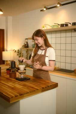 Önlüklü mutlu kadın, kahvesini ahşap tezgahın üstüne döker..