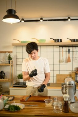 Genç adam ev yapımı sarımsaklı tereyağı yapmak için malzeme hazırlıyor..