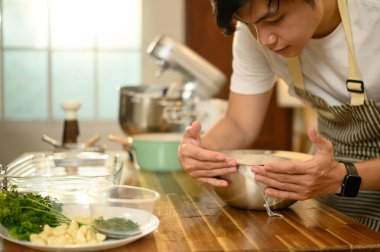 Adam çırpılmış kremayı plastik ambalajla kaplıyor, soğutmaya hazır..