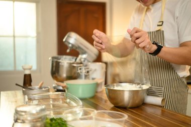 Adam çırpılmış kremayı plastik ambalajla kaplıyor, soğutmaya hazır..