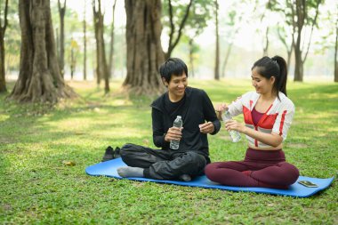 Genç çift açık hava egzersizinden sonra mola veriyor. Sağlık ve sağlıklı yaşam tarzı kavramı.