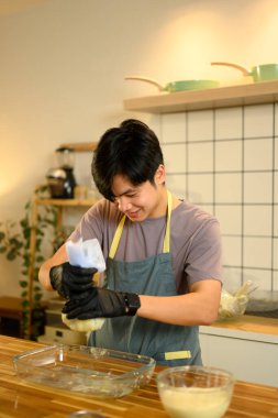Genç adam mutfakta tereyağından taze tereyağı sıkıyor..