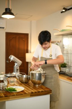 Adam ev mutfağında çırpılmış krema hazırlıyor..