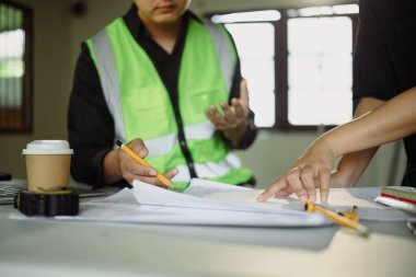 İnşaat alanının planlarını tartışan mühendisleri kapatın..