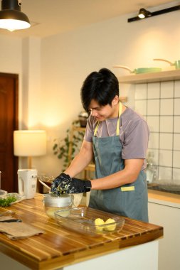 Eldivenli bir adam mutfakta tereyağı karışımından taze süt sıkıyor..