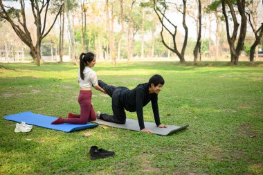 Açık havada yoga seansında esneme hareketleri yapan genç bir kadın..