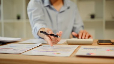 Profesyonel işadamı iş verilerini ve istatistikleri bir masada analiz ediyor.