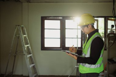 Yansıtıcı yelek ve başlık teftiş sahasında inşaat mühendisi..