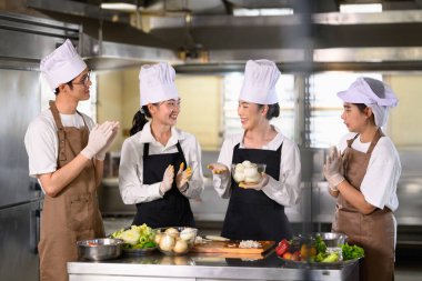 Yemek pişirme öğrencileri, öğrenme deneyiminin tadını çıkarıyor.