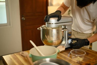 Genç Asyalı adam, mutfak mutfağında çırpılmış krema hazırlıyor..