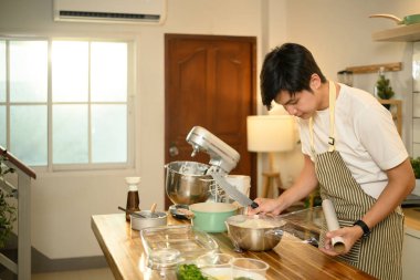 Genç erkek fırıncı depolama için krem şanti paketliyor..