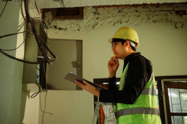 İnşaat alanındaki elektrik panelini denetleyen mühendis..