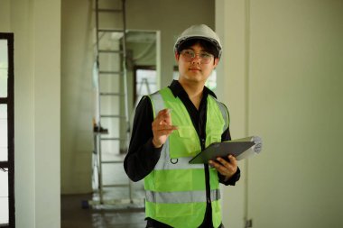 Tablet tutan mimar veya site denetleyicisi ve yenileme sahasındaki ilerlemeyi denetleyen.