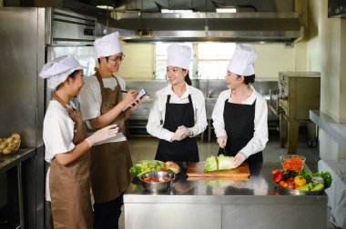 Ders sırasında öğrencilere sebze hazırlama konusunda rehberlik eden aşçılık eğitmeni..