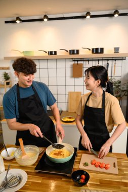 Gülümseyen çift mutfakta kahvaltı hazırlıyor..