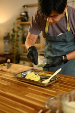 İnsan tereyağına taze otlar serper, ev yapımı tereyağı hazırlar...