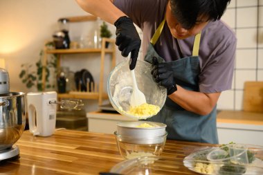 Sıvı tereyağı altında toplanırken kalın tereyağı tutan adam.