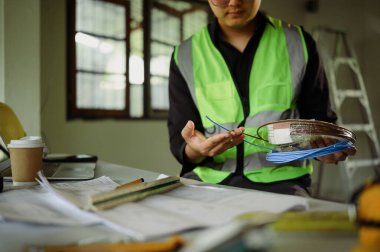 Bina tadilatı sırasında kablo makaralarını inceleyen teknisyenlerin kapatılması.