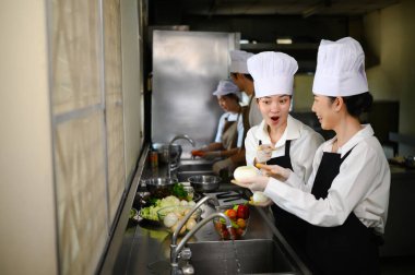 Aşçılık sınıfı katılımcıları aşçılık okulunda birlikte üretim yapıyorlar..