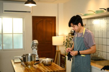 Genç adam tereyağını plastik ambalajla karıştırıyor..