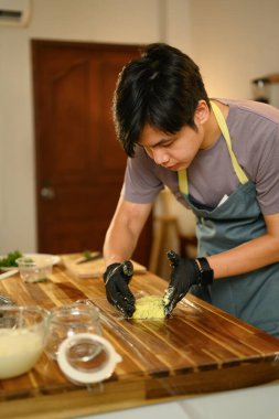 Siyah eldiven giyen adam ambalaj için tereyağı yapıyor..