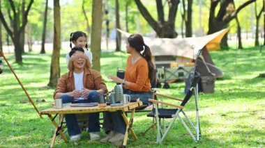 Neşeli küçük kız, ormanda neşeli bir aile kamp gezisi sırasında babasına sürpriz yapıyor..