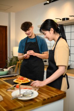 Çilekli krep servis etmeye hazırlanan neşeli genç çift..