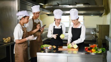 Aşçılık kursunda sebze hazırlama konusunda öğrencilere rehberlik eden aşçı..