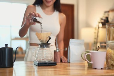 Yakın plan kahve telvelerini ahşap mutfak tezgahındaki damlatıcıya döküyorum..