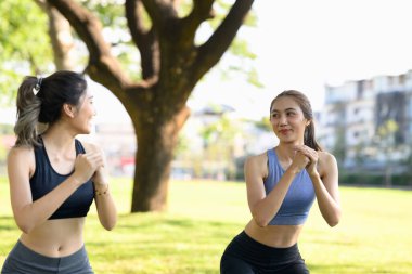 Spor giyim sektöründe formda Asyalı kadınlar doğada birlikte çalışıyor..