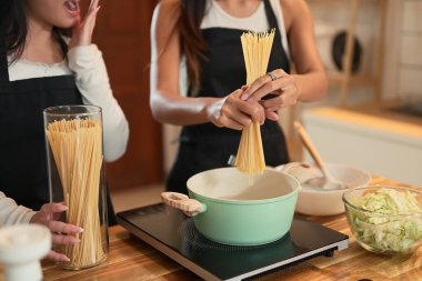 Annesi tencerede spagetti pişirirken, genç kızı şaşkınlıkla tepki veriyor..