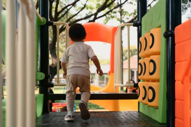Bebeklerin renkli açık hava oyun sahasında oyun saatlerinin tadını çıkardıkları arka plan görüntüsü.