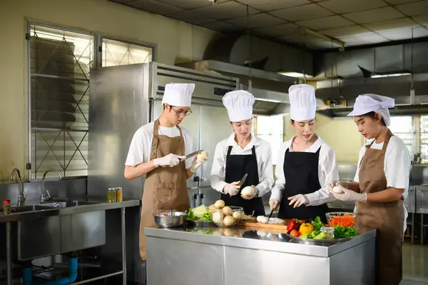 Aşçılık eğitmeni, öğrencilere bir eğitim oturumunda uygun bıçak teknikleri öğretiyor..