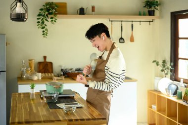 İnsan yemek pişirirken mikrofon gibi kaşıkla şarkı söyler...