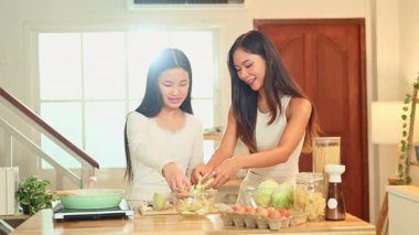 Genç Asyalı kız, annesiyle sıcak bir evde yemek yapmayı öğreniyor..