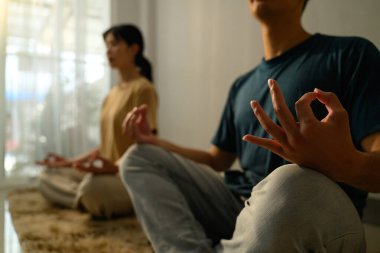 Genç çift sakin bir evde meditasyon yapıyor..