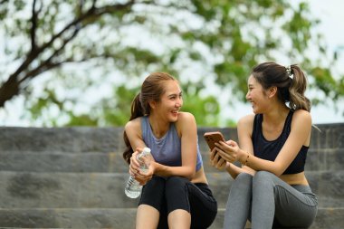 Sportif kadınlar taş basamaklarda rahatlar, idmandan sonra keyifli bir anı paylaşırlar..