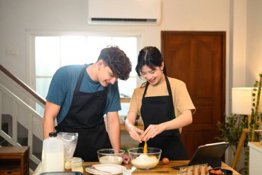 Gülümseyen çift mutfakta krep hamuru hazırlıyor..