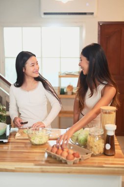 Mutlu anne ve kız mutfakta birlikte yemek hazırlıyorlar..