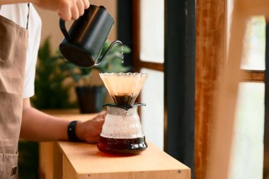 Mutfakta cam damlatıcı kullanarak kahve hazırlayan adama yaklaş..