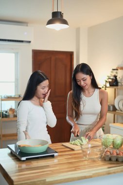 Mutlu anne ve kız mutfakta birlikte yemek hazırlıyorlar..