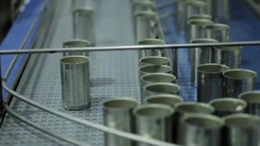 Konserve balık üretim hattında doldurulmak üzere taşınan metal kutuların kapatılması.