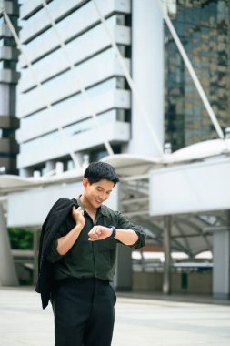 Modern iş adamı, şehir ticaret bölgesinde akıllı saatini kontrol ediyor..