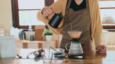 Kadının damlatıcıya sıcak su dökerek evdeki kahvenin üzerine dökme sahnesi.