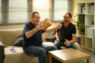 Mutlu baba oğlundan sürpriz bir hediye alıyor. Babalar Günü konsepti.