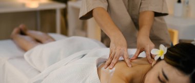 Masaj terapisti ona masaj yaparken rahatlamış kadın..