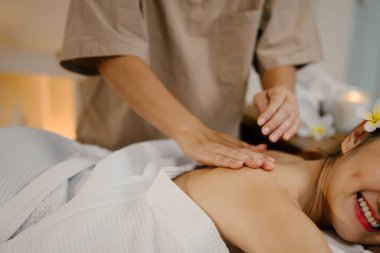 Masaj terapisti ona masaj yaparken rahatlamış kadın..