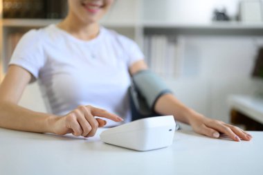 Yakın plan kadın düşük kan basıncını dijital basınç monitörü ve hipotansiyon problemi ile kontrol et..