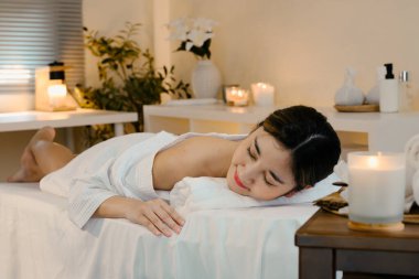 Kadın müşterinin sakin ve rahat bir odada tedavi yatağında dinlendiği spa terapisi konsepti..